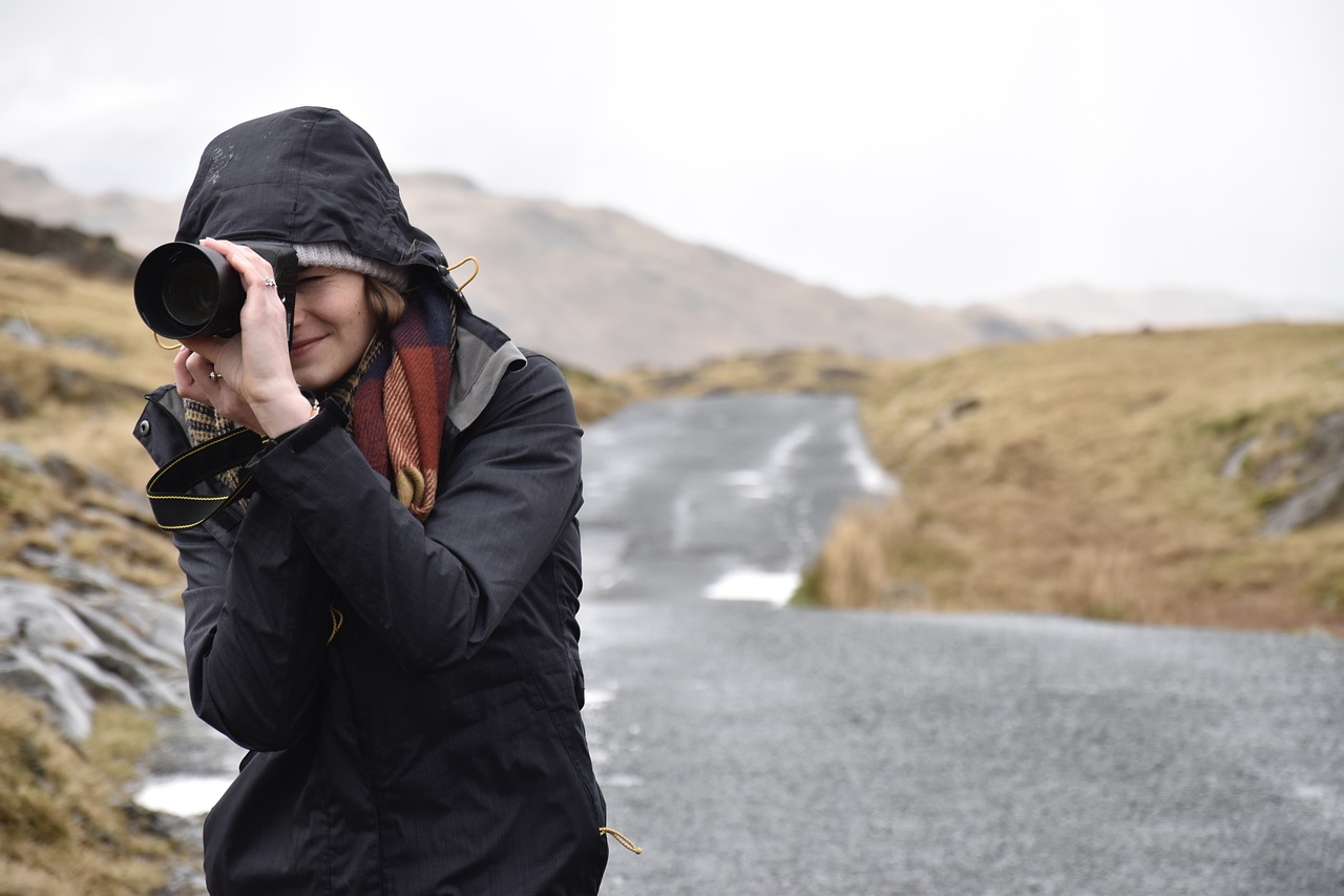 道路を撮影する女性カメラマンの画像